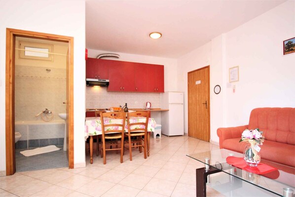 Un espace de vie compact comprenant un coin repas, une kitchenette et un canapé.