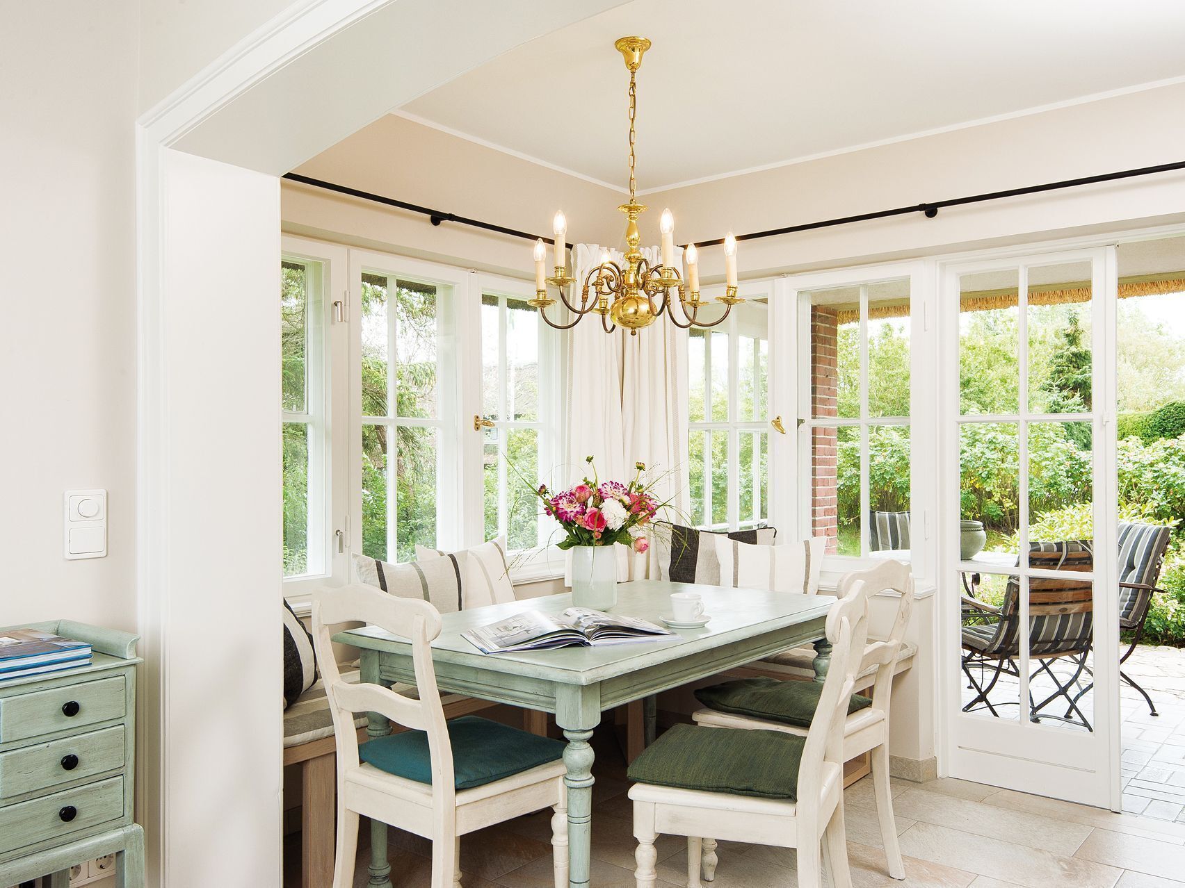 Un espace repas comprenant une table, des chaises et un lustre.