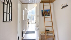 A hallway with a wooden ladder, a black metal gate, and a painting on the wall. - 5 bedroom awesome home in Herning (Herning)