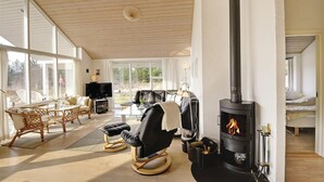 A cozy living room with a fireplace, comfortable seating, and a television. - 5 bedroom awesome home in Herning (Herning)