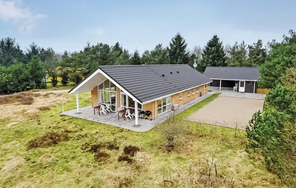 Un bâtiment moderne doté d’un patio couvert, de grandes fenêtres et d’un toit plat.