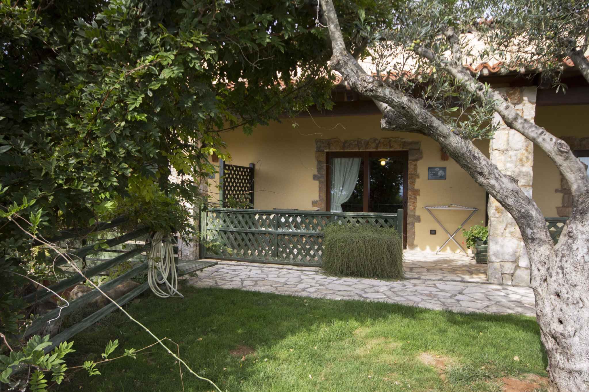 A stone pathway leading to a building with a wooden fence and a bench.