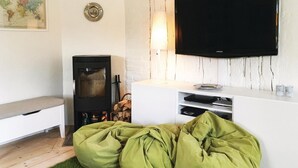 A cozy living room with a fireplace, a flat-screen TV, and a white entertainment unit. - Lovely home in Sollebrunn with WiFi (Sollebrunn)