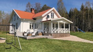 A white house with a red roof, a porch, and a swing set. - Lovely home in Sollebrunn with WiFi (Sollebrunn)
