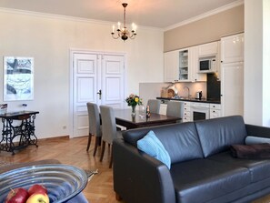 Un espace de vie compact comprenant un coin repas, une kitchenette et un canapé.