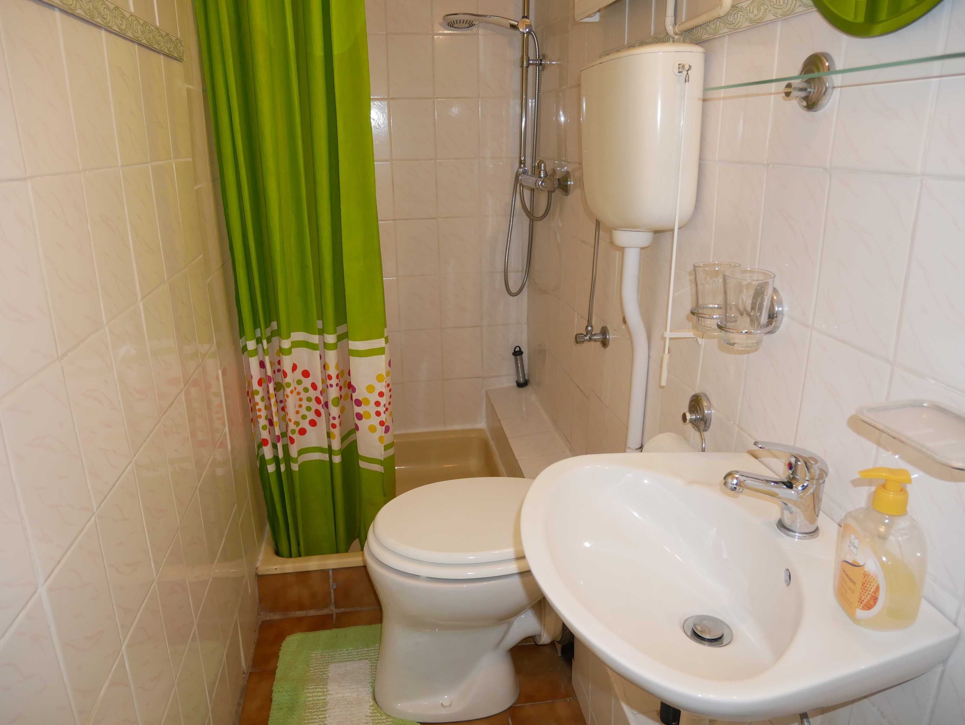 A bathroom with a toilet, sink, and shower.