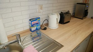 A kitchen with a sink, a box of Domol dishwashing liquid, a Philips coffee maker, a toaster, and a Toaster Oven. - Vacation apartment Kasch - Holiday apartment in the countryside (Krummin)