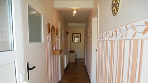A narrow hallway with striped walls, a wooden door, and a radiator. - Vacation apartment Kasch - Holiday apartment in the countryside (Krummin)