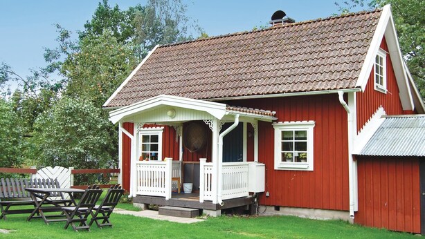 A red house with a white porch and a small deck. - Gorgeous home in Ruda with kitchen (Ruda)