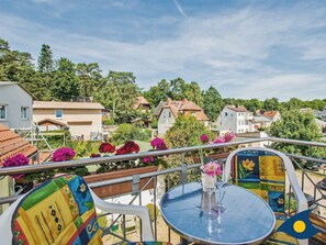 Une terrasse avec une table ronde, des chaises et une rambarde.