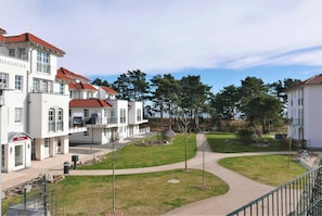 Un hôtel composé de plusieurs bâtiments blancs, dotés de toits rouges, et autour duquel s’étend une allée centrale.