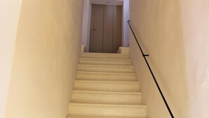 A narrow staircase with a door at the top.