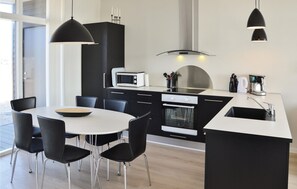 A modern kitchen with black cabinets, a white countertop, a microwave, an oven, and a coffee maker. - 2 bedroom lovely home in Ringkøbing (Ringkøbing)