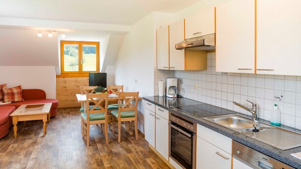 Une cuisine compacte avec un coin repas, un plancher en bois et une fenêtre offrant une belle vue.