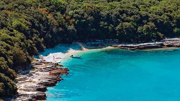 Une zone côtière caractérisée par des eaux turquoise et limpides, des rivages rocheux et une forêt verdoyante et dense.