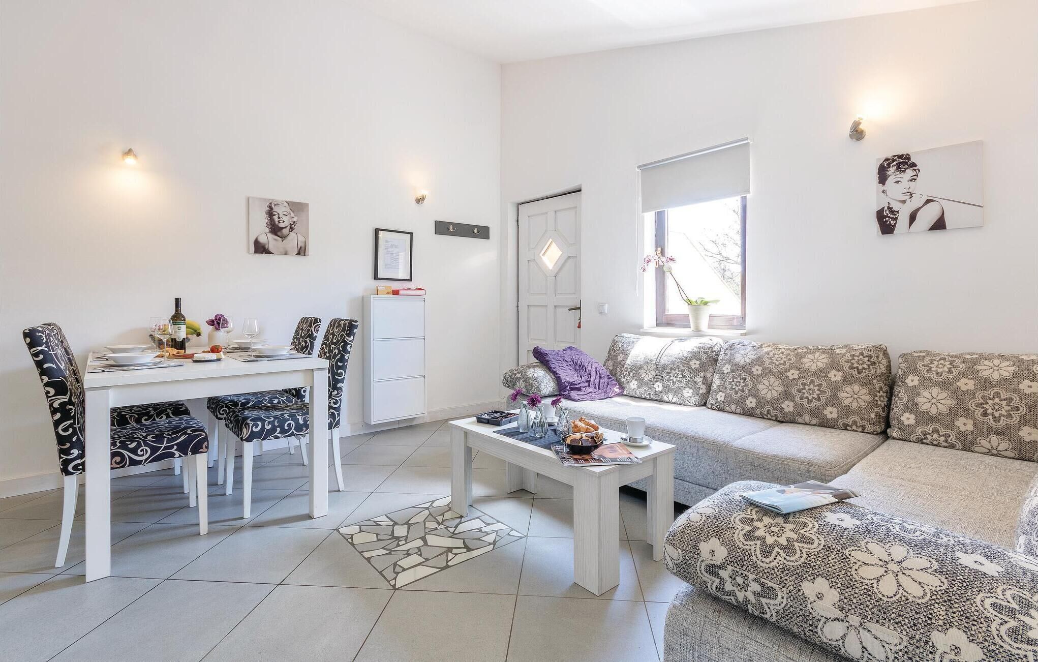 A modern living room with a dining area, a sofa, and a small table with decorative items.