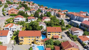 Un quartiere residenziale con case, una piscina e vista sul mare.