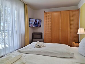 Ein Hotelzimmer mit einem Bett, einem Fernseher, einem Kleiderschrank und einem Nachttisch.
