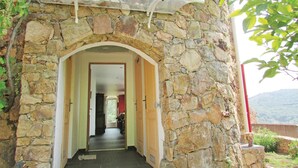 A stone archway leading into a building with a view of a mountain in the background. - Amazing apartment in Partinello (Partinello)