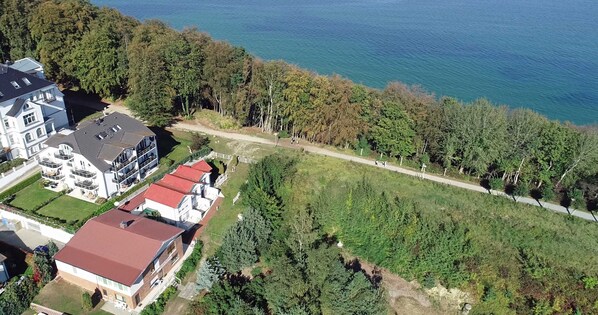 An aerial view of a residential area with houses, a pathway, and a body of water. - Alter Fritz sun terrace only a few minutes walk to the Baltic Sea - Alter Fritz (Sellin)