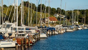 A marina with multiple boats docked at wooden piers, surrounded by greenery and houses. - Alter Fritz sun terrace only a few minutes walk to the Baltic Sea - Alter Fritz (Sellin)