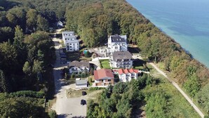An aerial view of a residential area with multiple houses, a clear road, and a coastline. - Alter Fritz sun terrace only a few minutes walk to the Baltic Sea - Alter Fritz (Sellin)