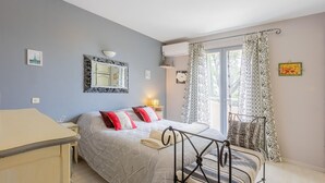 Ein Schlafzimmer mit Bett, Nachttisch, Spiegel und Vorhängen.
