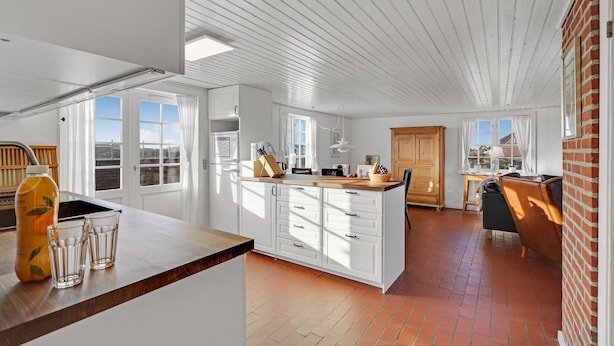 A spacious kitchen with white cabinetry, a wooden countertop, and a large window. - Gorgeous home in Fanø with kitchen (Fanø)