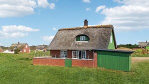 A traditional thatched-roof house with a brick base, a green door, and a small window. - Gorgeous home in Fanø with kitchen (Fanø)