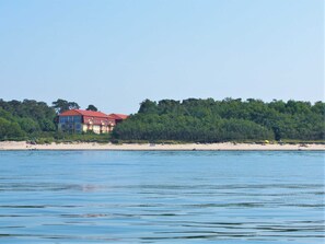 A beachfront hotel with multiple floors, a red roof, and a view of the beach and water. - Dune garden Whg. Wa47-38 - Wa47-38 (Kühlungsborn)
