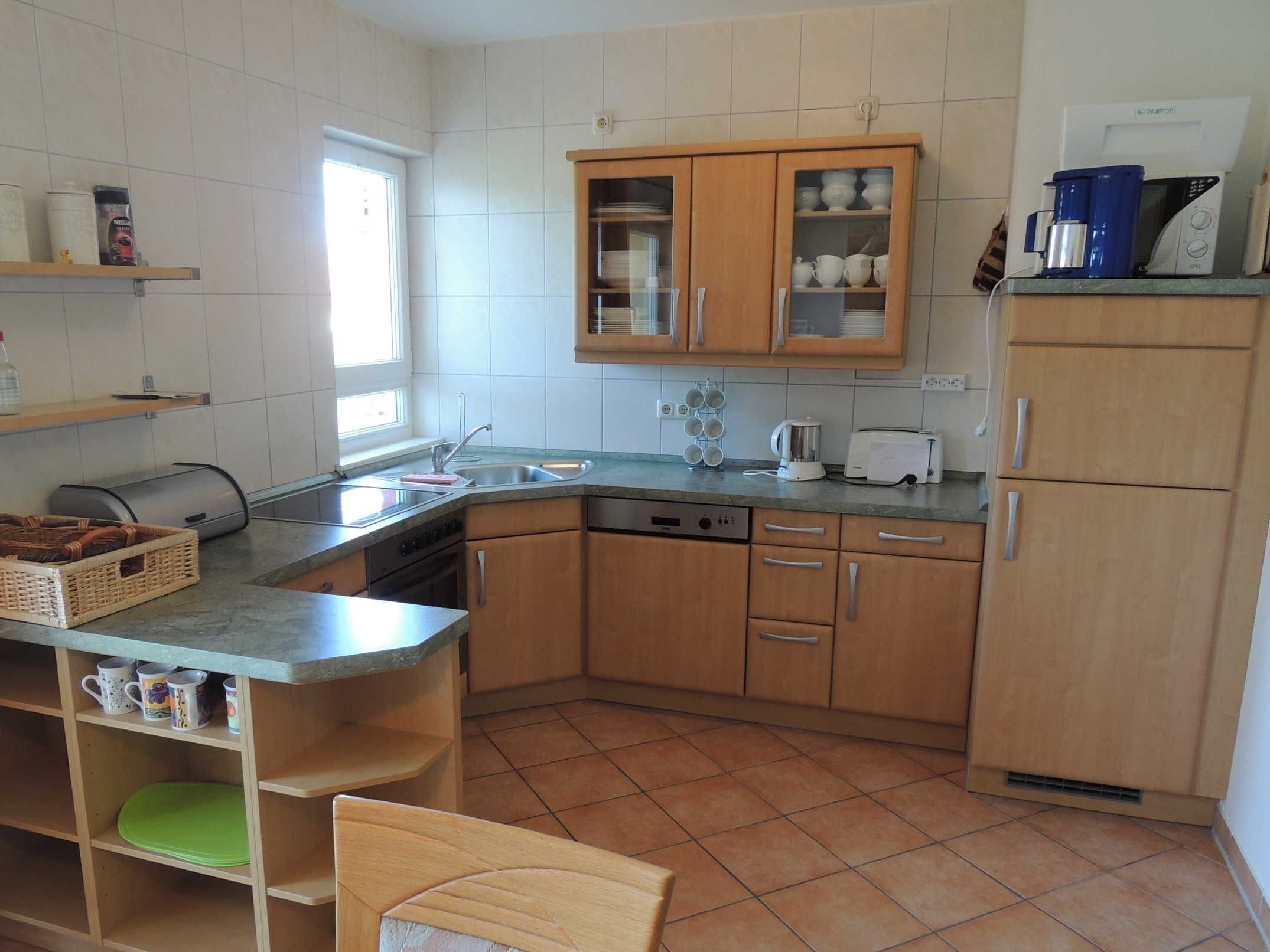 Cocina compacta con lavavajillas, cafetera y tostadora.