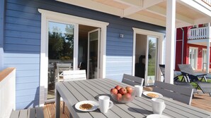 An outdoor dining area with a table set for two, a bowl of fruit, and a plate of waffles. - Stunning home in Süssau/Ostsee (Süssau/Ostsee)