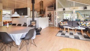 A modern interior with a dining area, kitchen, and living space. - Cozy home in Saltum with sauna (Saltum)