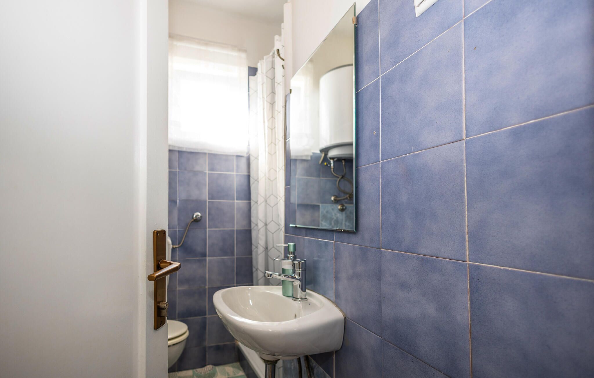 Une salle de bain avec un lavabo, un miroir et une douche.