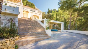 Una casa moderna con una scala in pietra che conduce a un'area esterna coperta.