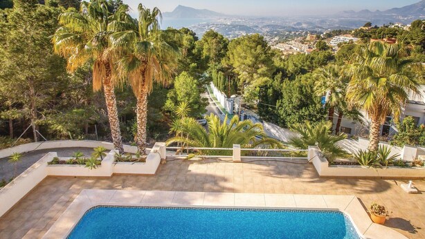 Una piscina con vista su una città e montagne sullo sfondo.