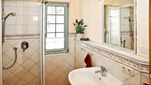 A bathroom with a shower, a sink, a window, and a mirror. - (293) 3-room apartment beach road - Apartment block LAGUNA (Kühlungsborn)