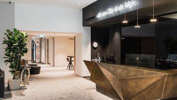 Un comptoir d’accueil au design moderne, une horloge et une enseigne au-dessus du comptoir.