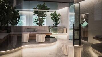 Ein modernes Interieur mit einer gewölbten Sitzgruppe, großen Fenstern und Zimmerpflanzen.