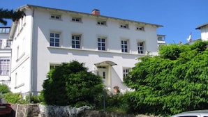 Ein weißes Gebäude mit vielen Fenstern und einem zentralen Eingang.
