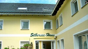 A building with a sign reading "Silbersee-Haus" and a stone wall with plants. - Tom and Jerry Vacation Rental - Silberseehaus in the Mortka Recreation Oasis (Lohsa)