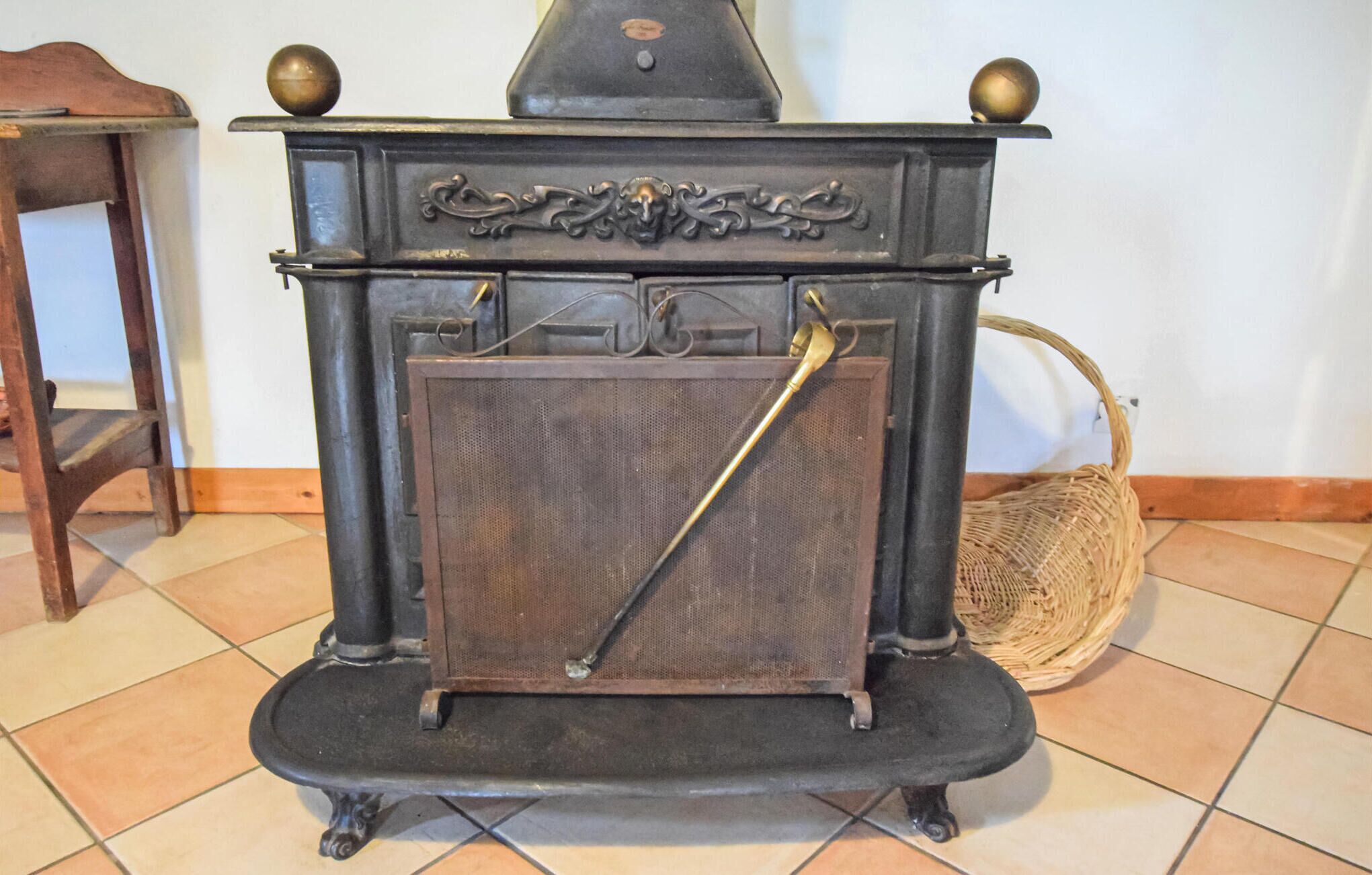 Un vecchio fornello con decorazioni in metallo elaborate e una maniglia in ottone.