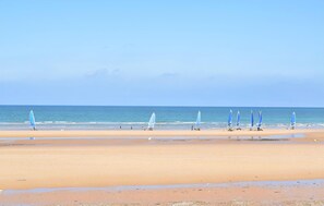 Ein Strand mit Windsurfgeräten und Personen.