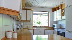 A kitchen with a wooden countertop, white cabinets, a window with a view, and a Bosch dishwasher. - 4 bedroom lovely home in Græsted (Græsted)