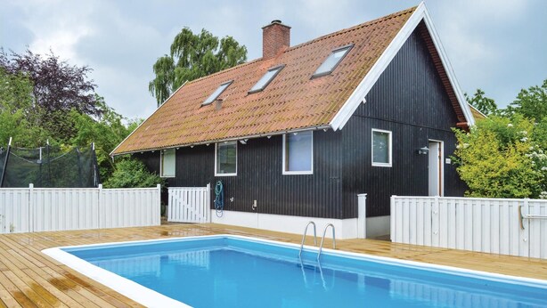 A modern house with a swimming pool, a wooden deck, and a fenced yard. - 4 bedroom lovely home in Græsted (Græsted)