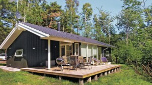 A cabin with a deck, outdoor seating, and a satellite dish. - Stunning home in Rønne with kitchen (Rønne)