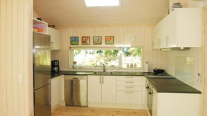 A compact kitchen with a dishwasher, a sink, and a window overlooking greenery. - Stunning home in Rønne with kitchen (Rønne)