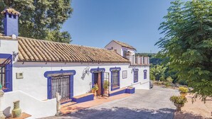 Un edificio tradicional con techo de tejas, marcos de ventana azules y un pequeño porche.