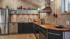 Eine moderne Küche mit Holzwänden, Edelstahlgeräten und einer Holzausziehtheke.