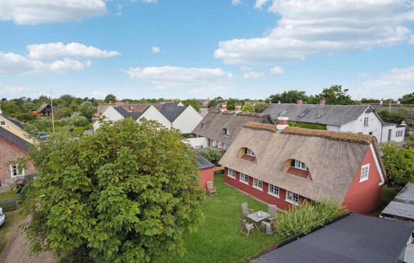 Uma área residencial com casas de telhados de palha e um gramado.